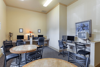 a room with two computers and two tables and chairs